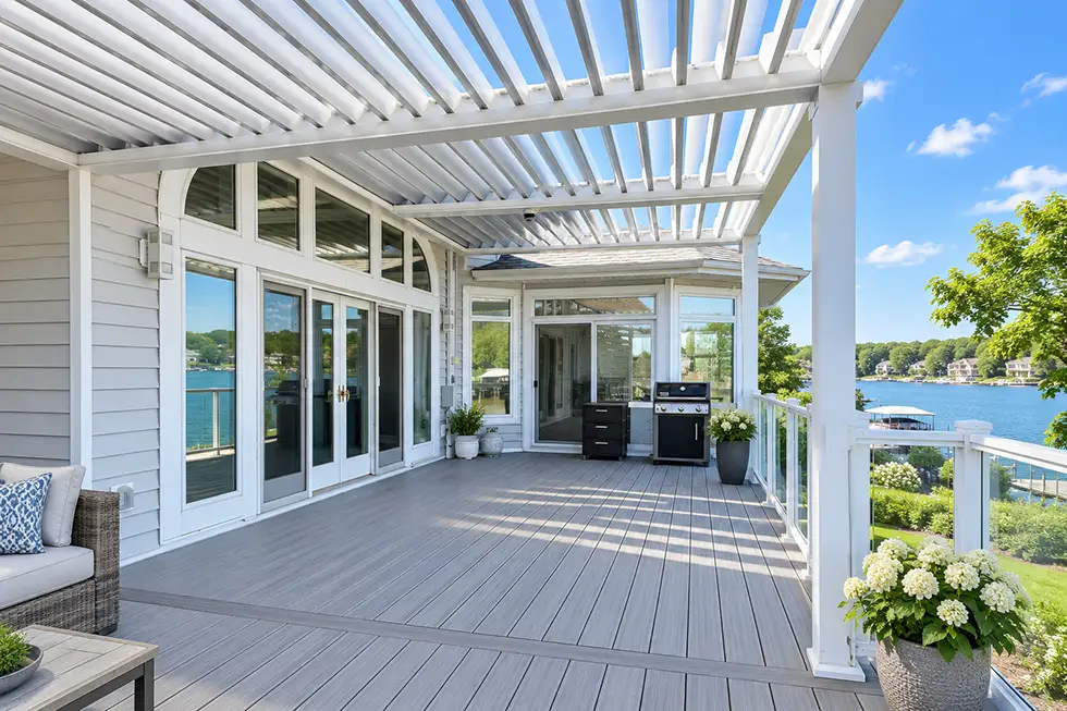 White motorized louvered pergola providing adjustable shade over a residential deck and outdoor living space